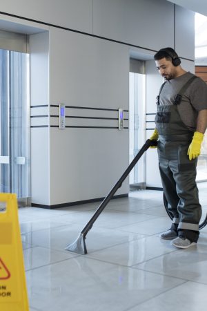 full-shot-man-vacuuming-floor